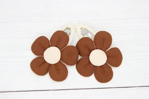 Detail of vintage flower hair clips with brown petals and white ribbon-wrapped metal grips