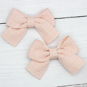 Coppia di fiocchi a quadretti rosa e bianchi per fermagli fai-da-te su legno bianco