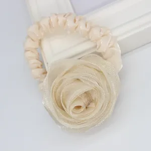 Detail of elegant beige mesh rose hair scrunchie with layered petals and satin pleats