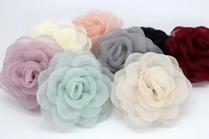 Vista detallada de broches de camelia en organza multicapa en varios colores elegantes