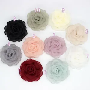 Detalle de broches de camelia en organza en siete colores elegantes y variados