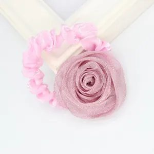 Detail of pink mesh rose hair tie with delicate fabric textures and elastic band