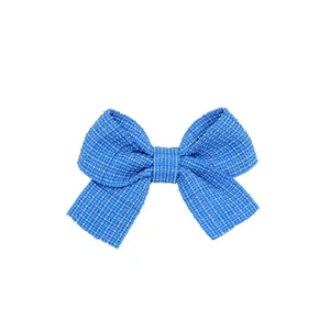 Vista macro di un fiocco per capelli in tweed blu con trama intrecciata e fascia centrale