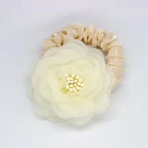 Détail du chouchou floral en organza crème avec perles et ruban en satin champagne
