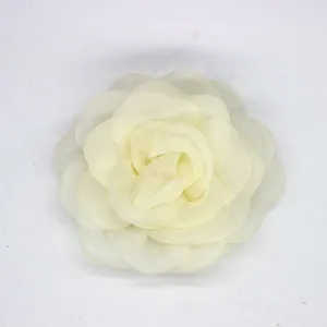 Detalle de accesorio para el pelo de flor de camelia en organza crema con pétalos en capas