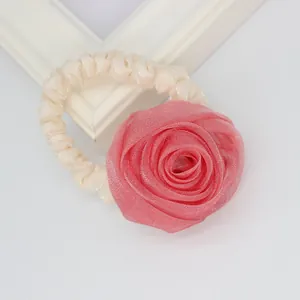 Close-up of pink mesh rose flower hair scrunchie with cream satin elastic band