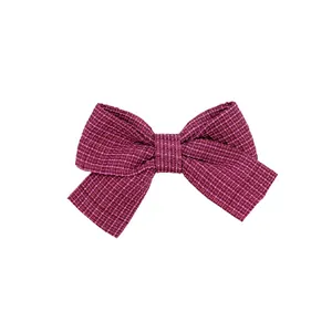 Dettaglio del fiocco in tessuto tweed rosa e bordeaux con trama intrecciata visibile