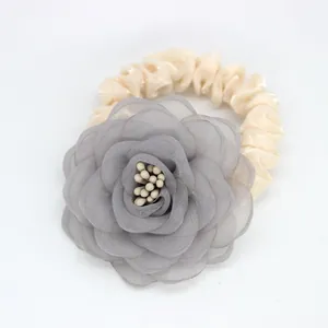 Détail d'un chouchou fleur en mousseline grise avec ruban satin et perles fines