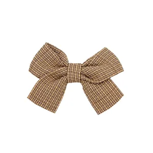 Vista dettagliata della clip a fiocco in tweed retrò da 7,5 cm con trama marrone e oro