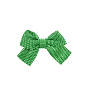 Dettaglio di un fiocco in tweed verde e bianco con finitura in tessuto intrecciato
