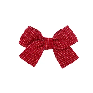 Dettaglio del fiocco per capelli in tweed a quadri rosso e rosa con trama tessuta