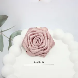 Dettaglio del fiore di rosa in nastro rosa fatto a mano da 5cm con fili dorati
