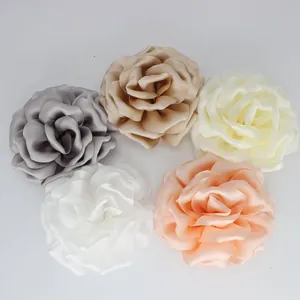 Detailed top view of five artificial satin peony flowers in varied elegant colors