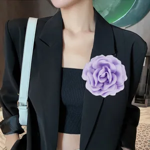 Detailed side view of 10cm purple satin rose brooch pinned on a black blazer lapel