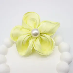 Gros plan détaillé d'une fleur en satin faite main avec perle d'imitation centrale