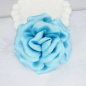 Light blue handmade satin fabric peony flower decoration on a white decorative plate