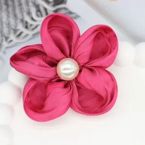 Détail d'une fleur en soie rose faite main avec perle centrale pour cheveux
