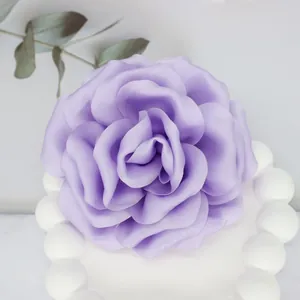 Macro shot of handcrafted 10cm purple satin fabric peony with detailed layered petals