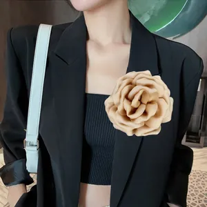 Detail of elegant beige satin flower brooch accessory pinned on a black suit lapel