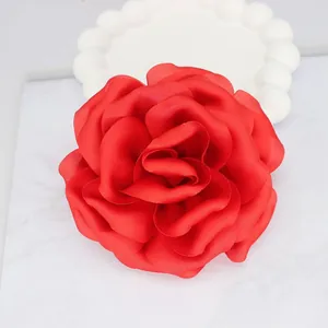 Macro detail of a 10cm red satin peony flower accessory with layered petals