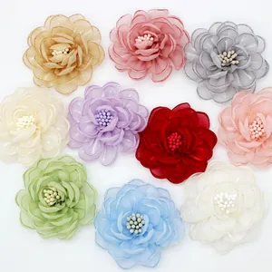 Flat lay of 10 colorful 5cm organza camellia flowers for DIY apparel and hair accessories