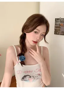 Detailed view of a vintage denim blue camellia flower hair tie on a model's braided hair