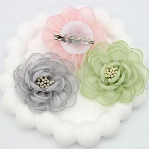 Detailed view of handmade 5cm organza flower accessories with centers and metal pins