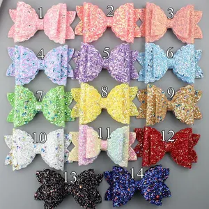 Flat lay of fourteen glitter bow straw toppers in various vibrant colors for tumblers