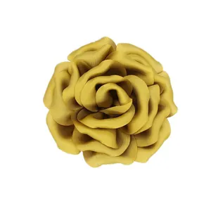 Detail of the multi-layered mustard yellow 3D fabric flower with elegant satin texture