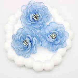 Macro detail of three light blue organza camellia flowers with delicate white pistils