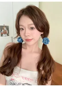 Detail showing two vintage blue denim camellia flower hair ties worn on a double ponytail