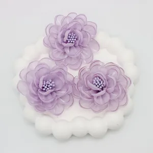 Detailed view of handmade lavender organza fabric camellia flowers with beaded centers