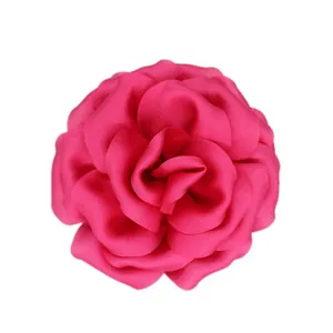 Detail of multi-layered rose red fabric flower pin with premium satin texture