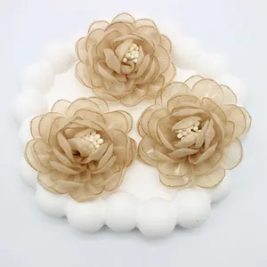 Detailed view of handmade 3D champagne organza camellia flower accessories with beads