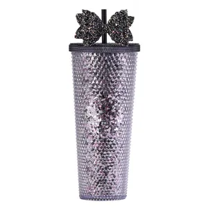 Close-up of sparkling purple textured tumbler with a large black sequin bow on the straw
