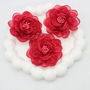 Macro shot of 5cm 3D fabric camellia flowers with intricate pink stamens for clothing accessories
