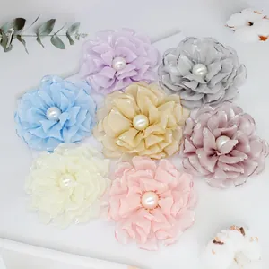 Detailed top view of handmade fabric peony flowers in seven soft pastel colors with pearls