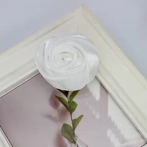 Detailansicht einer weißen Satin-Rosenknospe mit grünem Blatt für DIY-Zubehör und Deko