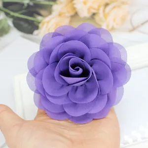 Dettaglio dell'elastico per capelli con rosa in chiffon viola tenuto in mano