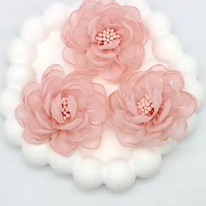 Macro view of three layered pink organza 3D flowers with delicate beaded centers