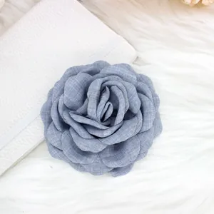 Close-up of a 9cm dusty blue denim fabric rose hair clip with detailed layered petals