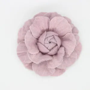 Detailed macro of a handmade vintage denim camellia flower hair accessory in dusty pink