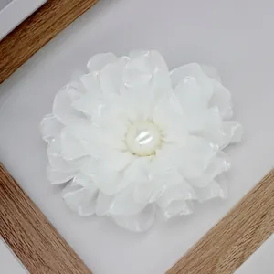 Detailed top view of a white multi-layered fabric peony flower with a center pearl detail