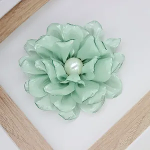 Macro detail of mint green fabric peony with multi-layer petals and pearl center