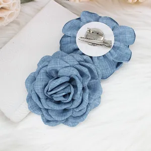 Detail of 9cm denim fabric rose showing the petal texture and dual brooch hair clip back