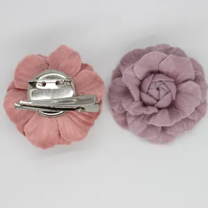 Detail of pink and purple denim camellia brooches with hair clip and safety pin back