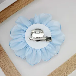 Rear view of light blue fabric peony flower with dual brooch pin and hair clip attachment