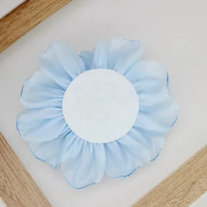 Detail view of the light blue chiffon flower back showing a white circular felt backing