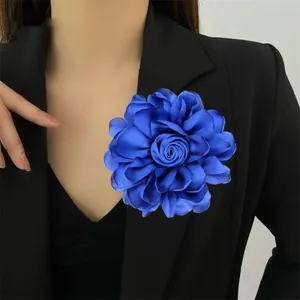 Große blaue Satin-Rosen-Brosche und Haarspange Accessoire an einem schwarzen Blazer