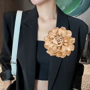 Satin-Rosen-Brosche in Champagnergold an einem schwarzen Blazer für einen edlen Look